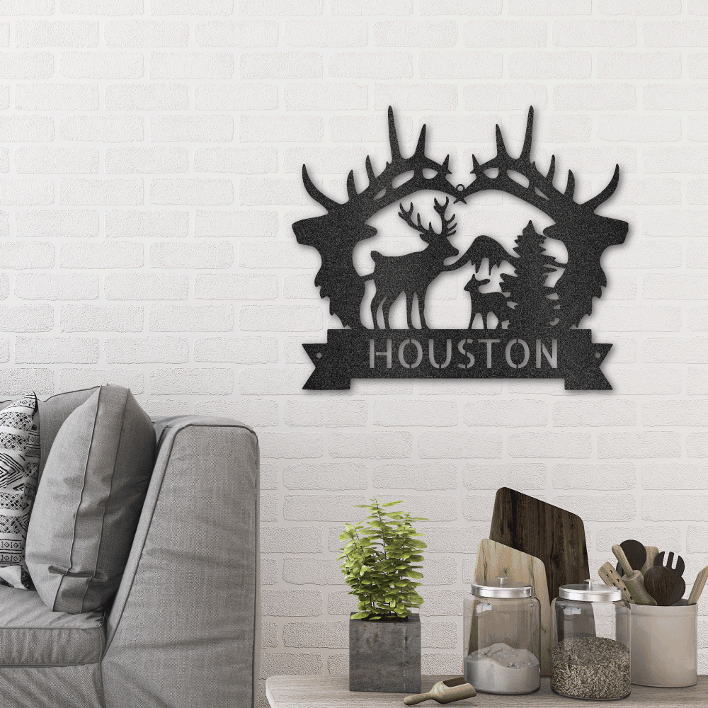 Metal wall art sign of 2 deer heads and a deer scenery. Personalize this design with your own custom name or message. This picture show the design in the color black hanging on the wall in the living room above a couch.