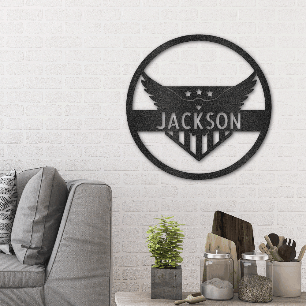 Metal wall art sign as home decor featuring a american bald eagle with the american flag inside a circle. Personalize this design with your own name or text. Hang it on the wall. Available in the color black. Hanging in the living room above a couch.