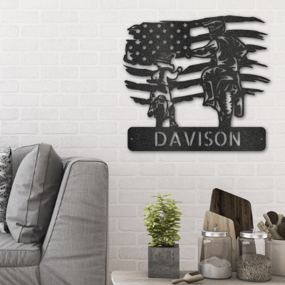 Metal wall sign of a motocross father and child on top of a custom name with the American flag as backdrop hanging on the wall