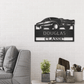 Metal wall art sign of a classic car with room for custom name or text underneath it. This picture shows the design in the color black hanging on the wall in the living room above a couch.