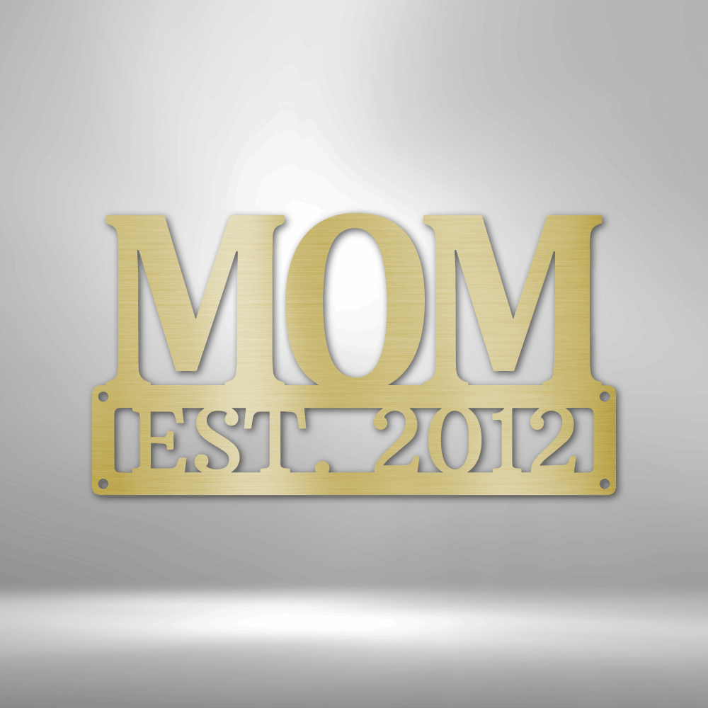 Metal Steel Sign with big letters MOM and underneath it is possible to add a custom text or name. The steel sign is hanging on the wall in the color gold