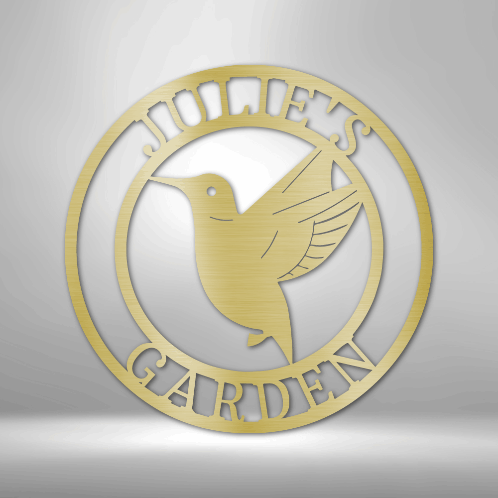 Metal Wall Art Sign of a hummingbird inside a ring that you can personalize with your own text or name. Hanging on the wall in het color gold