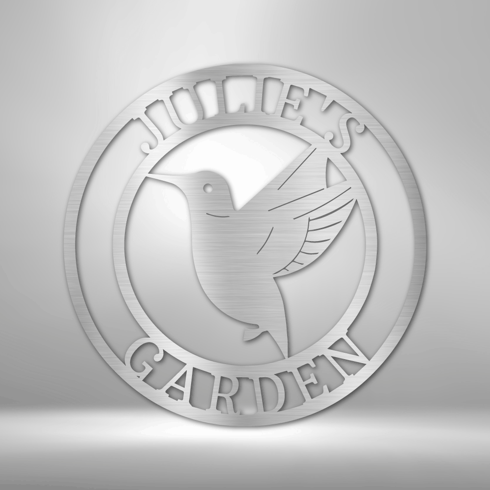 Metal Wall Art Sign of a hummingbird inside a ring that you can personalize with your own text or name. Hanging on the wall in het color silver
