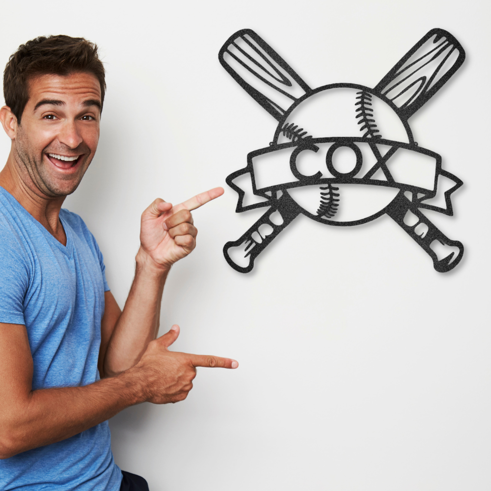 Metal wall art sign with a sport theme, this design shows baseball bats with a baseball ball and a banner that you can personalize with a custom name or text. This picture shows the design hanging on the wall in the color black